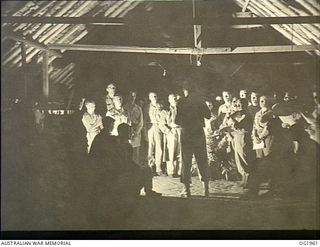 MADANG, NEW GUINEA. 1944-12-25. A RAAF CHOIR UNDER 263891 FLIGHT LIEUTENANT F. H. REID, ROSEVILLE, NSW, ENTERTAINING PATIENTS FOR CHRISTMAS AT A MEDICAL RECEIVING STATION