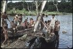 Fishing: people gather to get fish displayed on canoes that have just returned from overnight fishing