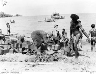 BIAMU, ORO BAY, NEW GUINEA. 1942-11-11. UNITED STATES STORES AND EQUIPMENT BEING UNLOADED FROM NATIVE CANOES AT BIAMU VILLAGE