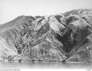 1943-04-20. NEW GUINEA. MILNE BAY. HILLS FALL SHEER TO THE WATER AND ARE COVERED WITH KUNAI GRASS FROM THREE TO TEN FEET HIGH. THE HILL SLOPES WERE LITTERED WITH THE BODIES OF JAPANESE WHO TRIED TO ..
