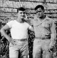 Ralph Gaugler and Jack Agnew by thatched building, New Caledonia