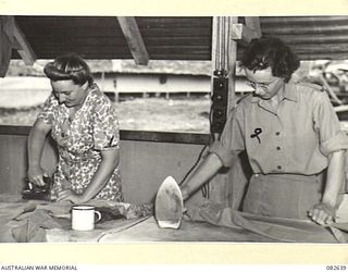 LAE AREA, NEW GUINEA. 1944-11-06. PRIVATE M. PRIOR (1), AND PTE E. THURBON (2), MEMBERS OF THE AUSTRALIAN ARMY MEDICAL WOMEN'S SERVICE, MAKING USE OF IRONING FACILITIES AT THE 2/7 GENERAL HOSPITAL