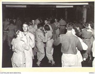 LAE, NEW GUINEA. 1945-11-25. THE DANCE FLOOR VIEWED FROM THE ORCHESTRA STAND DURING A DANCE AT THE AUSTRALIAN ARMY CANTEENS SERVICE OFFICERS' CLUB. THE CLUB IS SITUATED ON THE BANKS OF THE BUSU ..