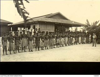 Ela Beach, New Guinea. 1944-05-10. Lieutenant R. Elliott, in-charge of the Officers Club, taking the morning parade of natives employed at the club