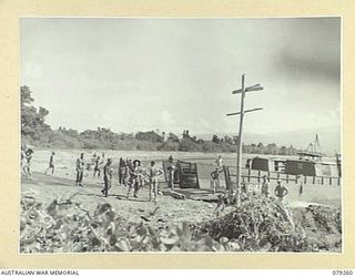 KALAI PLANTATION NEW BRITAIN. 1945-02-17. TROOPS OF THE 19TH INFANTRY BATTALION UNLOADING STORES AT THE PLANTATION BEACHHEAD