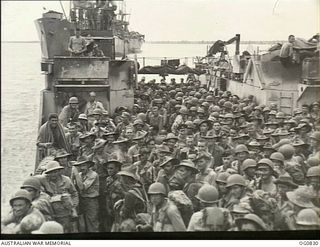 MOMOTE, LOS NEGROS ISLAND, ADMIRALTY ISLANDS. 1944-03-18. RAAF REINFORCEMENTS, TOGETHER WITH AMERICAN TROOPS, WAITING TO GO ASHORE FROM A LANDING CRAFT TANK