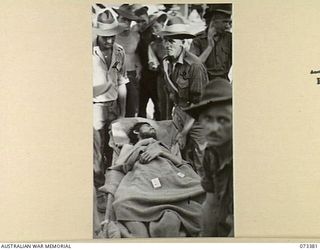 MADANG, NEW GUINEA. 1944-05-21. A JAPANESE PRISONER OF WAR BEING MOVED FROM AN AMBULANCE TO HMAS KAPUNDA WHICH IS MOORED ALONGSIDE THE WHARF. THE PRISONER, ONE OF A NUMBER CAPTURED AT MADANG ..