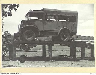 PORT MORESBY, PAPUA, NEW GUINEA. 1944-03-29. NX154772 DRIVER B.D. CULLEN AT TRANSPORT SECTION, HEADQUARTERS NEW GUINEA FORCE, CHECKING A VEHICLE ON THE RAMP