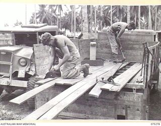 MADANG, NEW GUINEA. 1944-08-15. NX117682 PRIVATE J.J. O'RYAN, CARPENTER (1) AND NX125252 PRIVATE N.J. EASON, MOTOR BODY BUILDER (2) REPLACING THE FLOOR OF AN ARMY TRUCK AT THE 165TH GENERAL ..