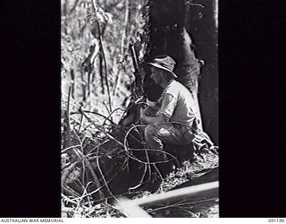 NUMA NUMA TRAIL, BOUGAINVILLE, 1945-04-24. PRIVATE E. A. LUXFORD, C COMPANY, 27TH INFANTRY BATTALION, GUARDS THE TRAIL TO BERRY'S HILL. THIS WAS PART OF THE FIRST ACTION FOR THE BATTALION ON ..