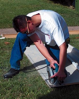 US Air Force STAFF Sergeant Gary Burton from the 15th Civil Engineering squadron, Hickam Air Force Base, Hawaii, cuts a kitchen counter while participating in the Families Helping Families program