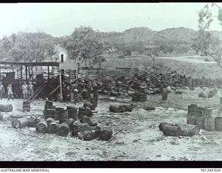 WARDS STRIP, PORT MORESBY, NEW GUINEA, 1943-03. HEAPS OF EMPTY TAR BARRELS BESIDE THE BUILDINGS AND MACHINERY OF THE HOT MIX BITUMEN PLANT. WARDS AERODROME WAS WORKED ON BY BOTH NO. 2 AND NO. 5 ..