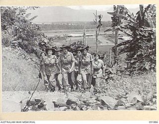 LAE, NEW GUINEA, 1945-05-18. PERSONNEL FROM THE AUSTRALIAN WOMEN'S ARMY SERVICE BARRACKS ON AN ARMY AMENITIES TOUR AROUND THE AREA SHORTLY AFTER THEIR ARRIVAL FROM AUSTRALIA. THEY ARE CLIMBING THE ..