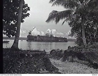 PACIFIC OCEAN. C.1945. WORK IS CARRIED OUT ON A CLEVELAND CLASS CRUISER AN ADVANCED BASE SECTIONAL DOCK OF THE US NAVY AT A PACIFIC ISLAND BASE. (NAVAL HISTORICAL COLLECTION)