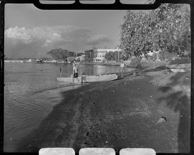 Papeete waterfront, Tahiti, showing two men getting ready to head out on their boats to fish