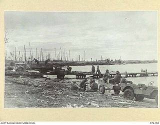 HANSA BAY, NEW GUINEA. 1944-06-22. PERSONNEL OF C COMPANY, 4TH INFANTRY BATTALION UNLOADING THE UNIT RATIONS AT THE JETTY