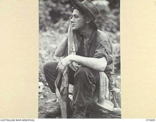 GAMAN, NEW GUINEA. 1944-05-27. NX142400 CORPORAL H.H. HINDS, 35TH INFANTRY BATTALION (1), RESTS DURING A PAUSE IN THE ADVANCE UP THE COAST TOWARDS WEWAK