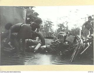 MADANG, NEW GUINEA. 1944. NATIVES LOADING THE COURIER BARGE OF THE 593RD UNITED STATES BARGE COMPANY WHICH RUNS A SERVICE BETWEEN MADANG AND ALEXISHAFEN FOR THE 5TH DIVISION