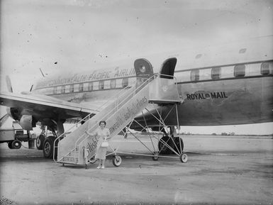 [Woman poses next to civilian plane]