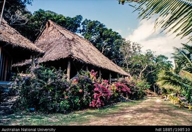 Fiji - thatched-roof building with flower garden