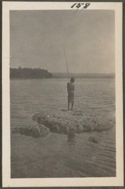 Man fishing from a coral reef, New Britain Island, Papua New Guinea, probably 1916