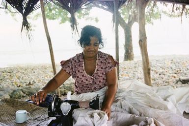 Woman sewing on beach