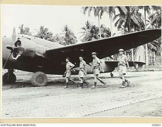 MILNE BAY, PAPUA. 1942-09. A LOCKHEED HUDSON BOMBER CREW OF THE RAAF GOING TO THEIR PLANE TO GO OUT ON A RAID OVER ENEMY BASES. LEFT TO RIGHT:- FLYING OFFICER H. ROBERTSON, SERGEANT F. CARDEN, ..