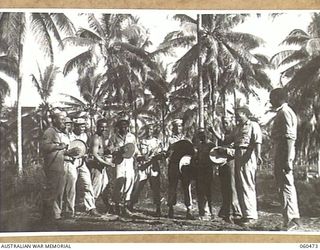 LANGEMAK BAY, DREGER HARBOUR, FINSCHHAFEN AREA, NEW GUINEA. 1943-11-11. COLOURED ENGINEERS OF THE 808TH UNITED STATES ENGINEER AVIATION BATTALION USING KITCHEN UTENSILS FOR AN IMPROMPTU BAND ..