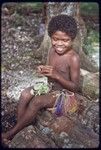 Child making a garland of small flowers