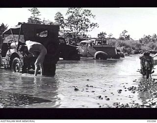 MILNE BAY, NEW GUINEA. 1943-06-26. DRIVERS OF HEADQUARTERS, 5TH AUSTRALIAN DIVISION WASHING THEIR VEHICLES AT HAGITI BRIDGE ON THE KALOHI CREEK