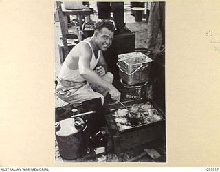 WEWAK POINT, NEW GUINEA. 1945-08-29. CORPORAL C.J. BAILEY, COOK, A COMPANY, 2/8 INFANTRY BATTALION, MAKING FISH PATTIES FOR LUNCH