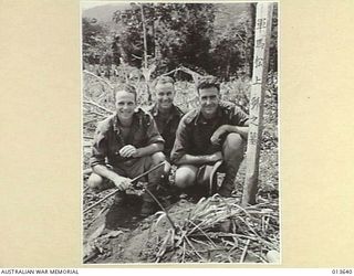 1942-11-23. NEW GUINEA. KOKODA. BESIDE A JAPANESE GRAVE ARE THREE DIGGERS LT. E.R. BLACKFORD (VIC) CPL. A.H.J. SHEPHERD (N.S.W.) AND SGT. B. KING (N.S.W.). (NEGATIVE BY G. SILK)