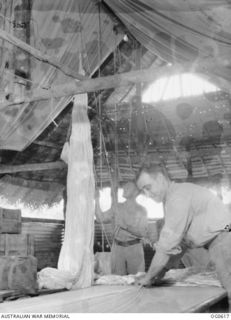 VIVIGANI, GOODENOUGH ISLAND, PAPUA. C. 1943-10. AT NO. 30 BEAUFIGHTER SQUADRON RAAF, PARACHUTE SECTION, PARACHUTES ARE HUNG UP FOR DRYING AS SOON AS THEY ARE HANDED IN FOR INSPECTION. THERE ARE ..