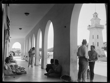 Locals on the BP Building veranda adjacent to the beach front clock tower, Apia, Western Samoa