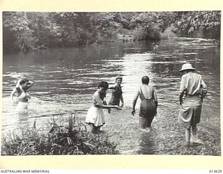 1942-11-23. UNITED STATES NURSES IN NEW GUINEA. RELAXATION IN A SWIMMING HOLE NEAR THE CAMP. (NEGATIVE BY BOTTOMLEY)