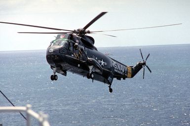 An SH-3 Sea King of the Seventh Fleet Command flies by the amphibious command ship USS BLUE RIDGE (LCC-19)