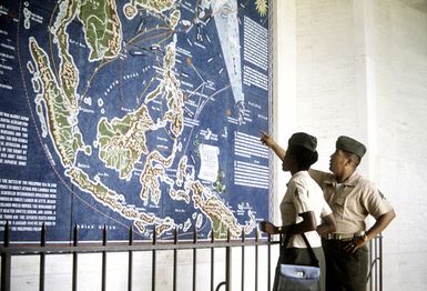 SGT Everett and SGT Sanchez look at a map showing the locations of Pacific battle campaigns of World War II during their visit to the museum at the Pacific National Memorial Cemetery
