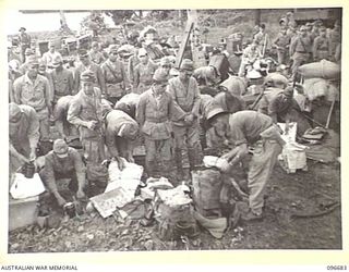 KAIRIRU ISLAND, NEW GUINEA. 1945-09-17. WARRANT OFFICER 2 D.W. TREADWELL, FIELD SECURITY SERVICE, HEADQUARTERS 6 DIVISION GOING THROUGH THE BELONGINGS OF JAPANESE NAVAL FORCES PRIOR TO THEIR ..