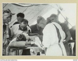 MELBOURNE, VICTORIA, AUSTRALIA. 1944-03-03. COPY OF A SCENE FROM A CINE STRIP OF A DOCTOR OPERATING ON A WOUNDED SOLDIER IN NEW GUINEA