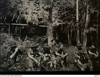 Nuginiklub, New Britain. 1945-07-28. A patrol of members of the 2/2nd Cavalry Commando Squadron, AIF, pause for a rest as they move inland after leaving the Henry Reid Bay area at Lamarien