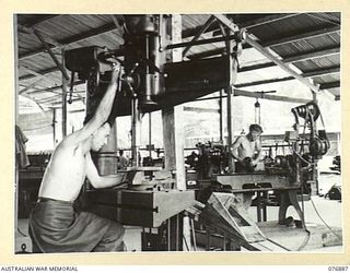 LAE AREA, NEW GUINEA. 1944-11-15. VX60112 CRAFTSMAN G.A. MASON (1) OPERATING A RADIAL DRILL AND QX43235 CRAFTSMAN H.L. WILLIS (2) OPERATING A "VANGUARD" LATHE IN THE GENERAL ENGINEERING SECTION OF ..