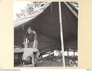 DALLMAN, WEWAK AREA, NEW GUINEA. 1945-08-28. LIEUTENANT R.P. MORGAN, 2/1 TANK ATTACK REGIMENT ROYAL AUSTRALIAN ARTILLERY, IRONING HIS CLOTHES