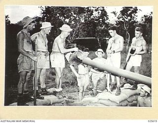 PORT MORESBY, PAPUA. 1942-07. WASHING OUT A GUN BARREL AFTER THE "ALL-CLEAR" HAS SOUNDED IN A NEW GUINEA AREA. THIS IS A ROUTINE JOB THAT FOLLOWS JAPANESE RAIDS