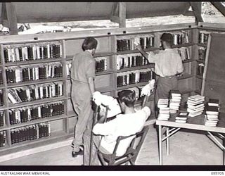 RABAUL, NEW BRITAIN, 1946-01-17. MISS PARRATT, RED CROSS SOCIETY FIELD HOSPITAL VISITOR, ASSISTED BY A PATIENT, CHECKING BOOKS ON THE SHELVES OF THE LIBRARY AT 118TH AUSTRALIAN GENERAL HOSPITAL, ..