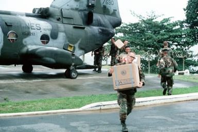 Marines unload boxes of supplies from a Marine Medium Helicopter Squadron 261 (HMM 261) CH-46E Sea Knight helicopter on the grounds of the US Embassy. Marines of the 22nd Marine Expeditionary Unit (22nd MEU), deployed aboard the amphibious assault ship USS SAIPAN (LHA 2), were sent to augment security at the embassy as part of Operation SHARP EDGE