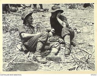 FARIA VALLEY, NEW GUINEA, 1944-02-09. NX104106 CORPORAL J.C. LEE (1) AND SX707 LIEUTENANT I.C. EDWARDS (2) MEMBERS OF THE 2/10TH INFANTRY BATTALION, RESTING AT BEVERIDGE'S POST