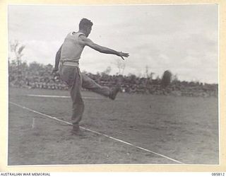WONDECLA AREA, QLD. 1945-01-19. PRIVATE E ORR, 2/2 PIONEER BATTALION, 2 BEACH GROUP, COMPETING IN THE "KICKING THE FOOTBALL" EVENT DURING THE 9 DIVISION GYMKHANA AND RACE MEETING HELD AT THE ..