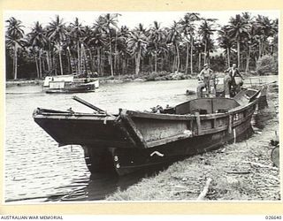 MILNE BAY, PAPUA. 1942-09. ONE OF THE JAPANESE INVASION BARGES USED IN THEIR ABORTIVE LANDING ATTEMPT AT MILNE BAY, NOW SALVAGED AND PUT INTO USE BY AUSTRALIAN ENGINEERS