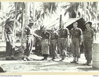 SIAR, NEW GUINEA. 1944-06-20. VX104470 LIEUTENANT L.R. MARSH, ORDERLY OFFICER (2), INSPECTING THE COOKS IN THE KITCHEN OF A COMPANY, 58/59TH INFANTRY BATTALION. IDENTIFIED PERSONNEL ARE:- VX102543 ..