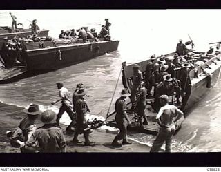 LANGEMAK BAY, NEW GUINEA. 1943-10-20. LANDING CRAFT LOADED WITH TROOPS OF THE 2/24TH AUSTRALIAN INFANTRY BATTALION EN ROUTE FOR LAUNCH JETTY FOR FINAL PREPARATIONS TO ATTACK SATTELBERG IN THE ..